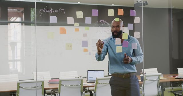 Businessman Brainstorming with Sticky Notes on Office Glass Wall - Download Free Stock Images Pikwizard.com