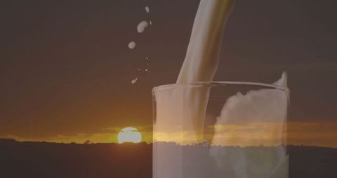 Milk Pouring into Glass with Rural Sunset Backdrop