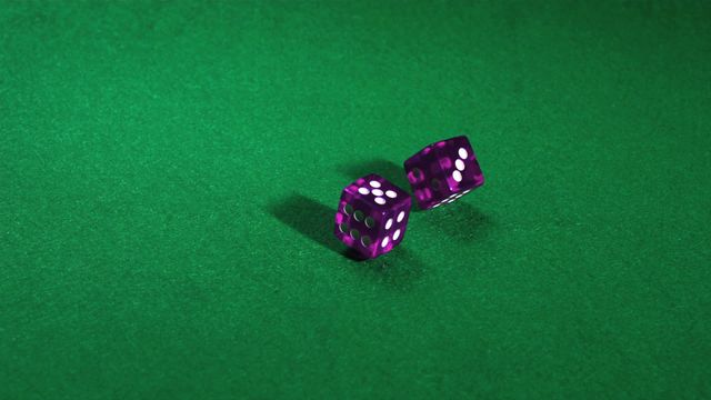 Purple dice tumbling on bright green table, often used to represent gaming, probability, or gambling themes. Perfect for illustrating concepts of luck and chance in casino-related content, game designs, or educational materials on probability.