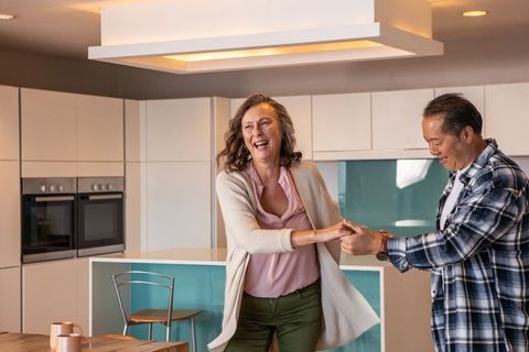 Joyful Senior Couple Dancing in Modern Kitchen
