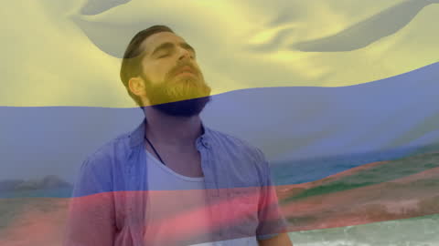 Pensive Bearded Man at Beach Merged with Colombian Flag