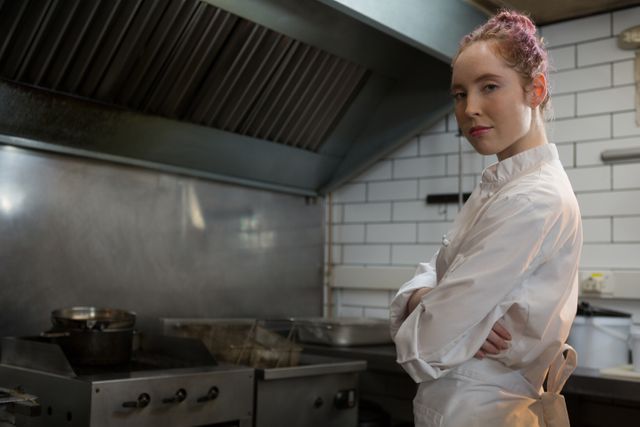 Portrait of smiling female chef with hands crossed in the kitchen