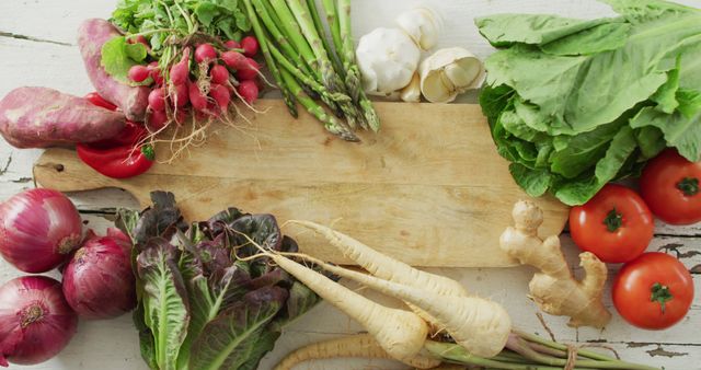 Colorful assortment of fresh organic vegetables displayed around a wooden board. Perfect for promoting healthy eating, vegetarian recipes, farmers markets, cooking blogs, or grocery store advertisements.