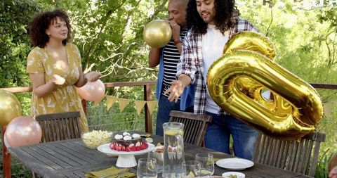 Friends Preparing Terrace for Lively Birthday Party Celebration