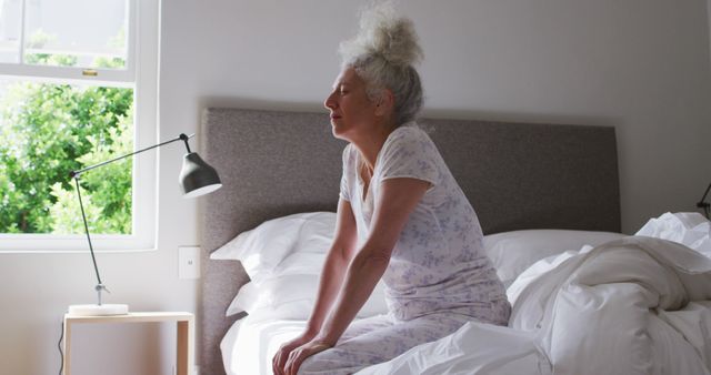 Elderly Woman Stretching on Bed in Bright Morning Light - Download Free Stock Images Pikwizard.com