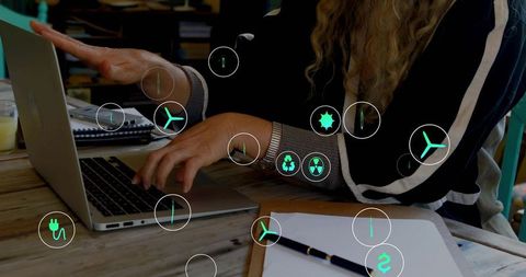 Typing woman analyzing energy data with floating AR sustainability icons on laptop at wooden table