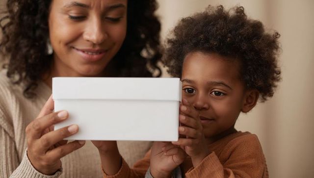 Mother and child exploring white gift box together at home in warm neutral tones