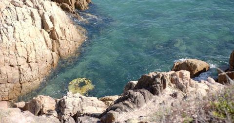 Rocky Coastline with Submerged Tire in Clear Blue Water - Download Free Stock Images Pikwizard.com