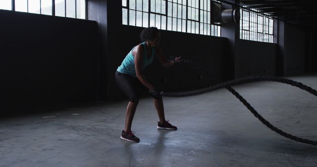 Woman Engaging in Battle Rope Workout in Industrial Gym - Download Free Stock Images Pikwizard.com