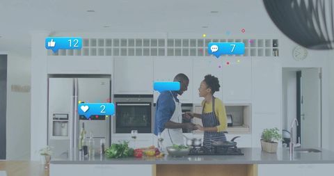 Couple cooking together in modern kitchen with social media reaction overlays and island