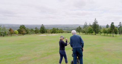 Senior Couple Enjoying Day on Scenic Golf Course