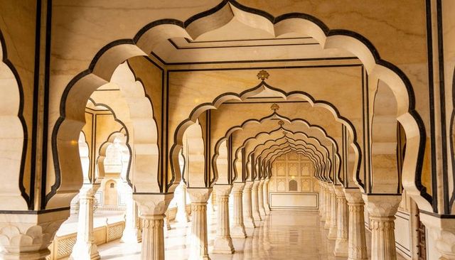 Golden marble arcade with receding scalloped arches and polished reflective floor