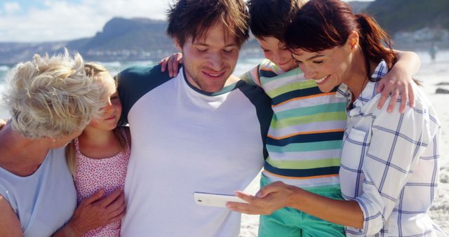 Happy Multigenerational Family Looking at Smartphone on Beach - Download Free Stock Images Pikwizard.com