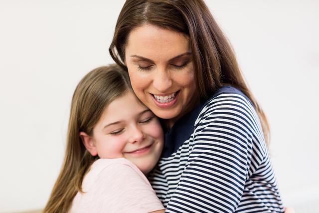 This image captures a tender moment between a mother and her daughter, showcasing their close bond and affection. Ideal for use in family-oriented content, parenting blogs, advertisements for family services, or any material promoting love and togetherness.