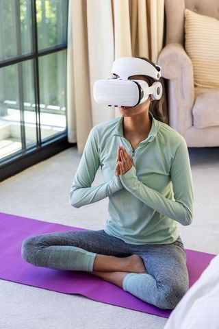 African american woman practicing vr meditation on yoga mat at home for mindfulness