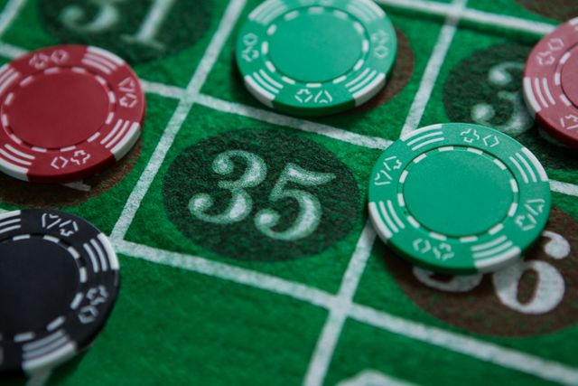 Close-up of a roulette table with various betting chips placed on number 35. Ideal for illustrating gambling, casino games, or entertainment themes. Can be used in articles about casino strategies, gambling addiction awareness, or promotional materials for casinos.