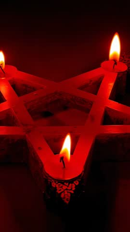 Vertical video showing wooden star candle holder with three flickering candles in warm glow