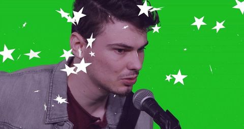 Singer performing in studio with green screen star effects