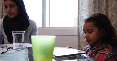 Mother and Daughter at Kitchen Table with Tablets