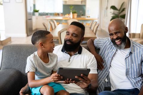 Multigenerational African American Family Enjoying Tablet in Modern Living Room