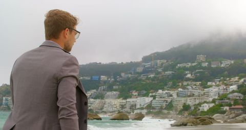 Businessman walking barefoot on misty beachfront