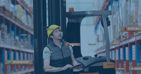 Warehouse worker operating forklift using digital tablet
