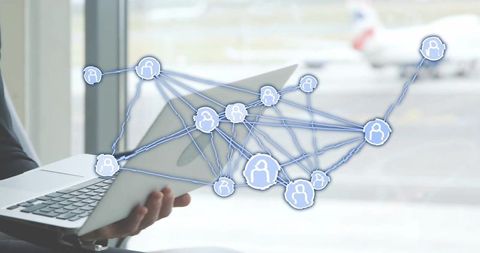 Executive holding laptop at airport accessing digital network for business connectivity