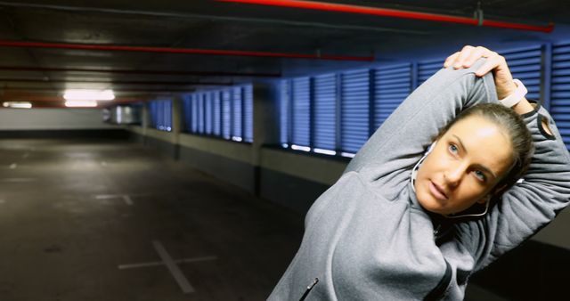 Woman Stretching Arms in Underground Parking Garage - Download Free Stock Images Pikwizard.com