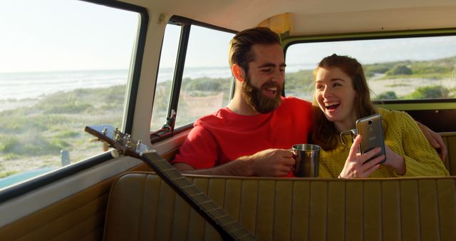 Happy couple using mobile phone in the van. Couple spending time together 4k