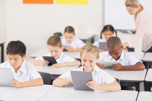 Students are actively using digital tablets in a classroom environment, guided by a teacher. This image can be used to depict modern educational methods, integration of technology in schools, and engaged learning. Ideal for educational websites, articles on digital learning, and promotional material for educational technology.