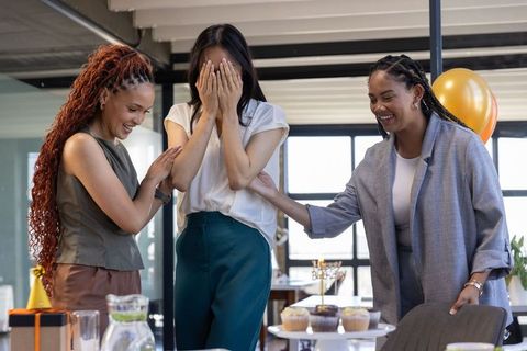 Diverse coworkers celebrating surprise party in office