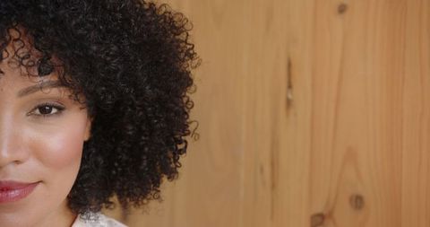 Elegant afro-haired woman posing in minimalist setting