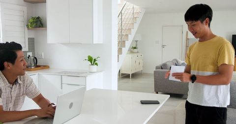 Father and Son Engaging in Discussion in Modern Kitchen Concept