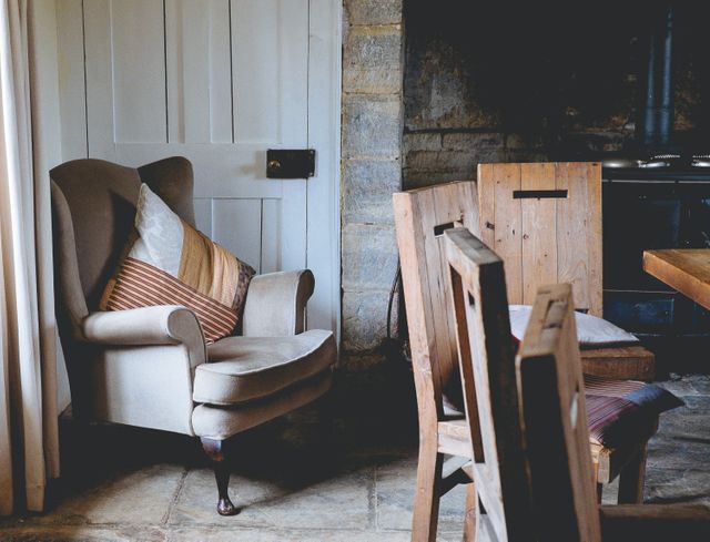 Cozy Rustic Living Room with Armchair and Wooden Chairs - Download Free Stock Photos Pikwizard.com