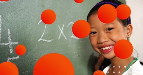 Smiling Schoolgirl at Chalkboard Engaged in Learning