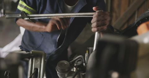 Mechanic Tightening Engine Bolts with Breaker Bar Closeup in Garage Workshop