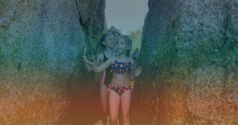 Children exploring narrow rock passage on summer adventure