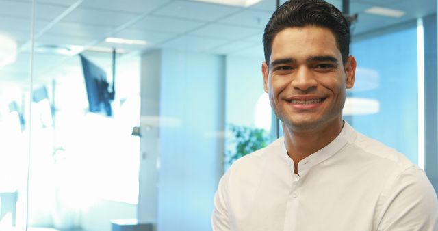 Confident Businessman Wearing White Shirt Smiling in Modern Office - Download Free Stock Images Pikwizard.com