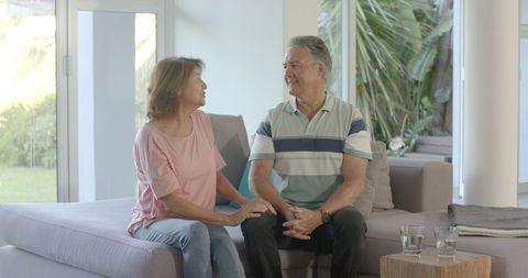 Senior Couple Enjoying Conversation on Couch Indoors