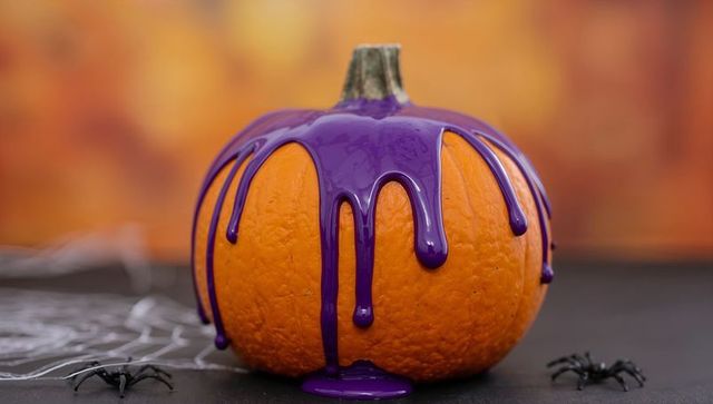 Halloween pumpkin dripping purple paint with spiders