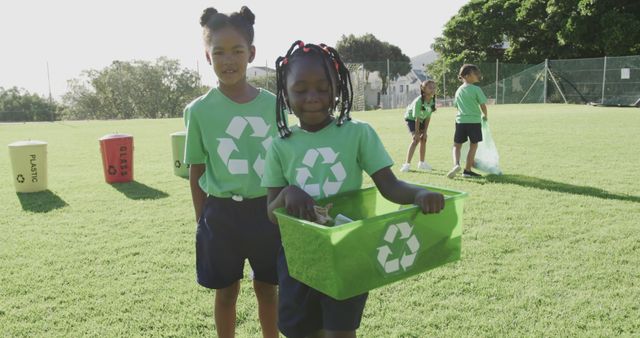 Children actively engage in recycling efforts outdoors, promoting eco-friendly practices and environmental awareness. Ideal for campaigns on environmental conservation, educational materials, community event promotions, and sustainability projects.