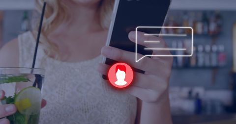Woman Engaging with Digital Icons on Phone in Bar Setting