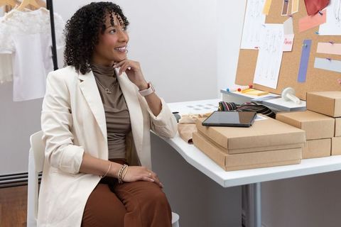 African american fashion designer planning boutique packaging in modern studio workspace