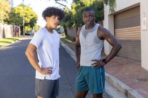 Two Male Friends Resting After Outdoor Workout in Suburban Neighborhood