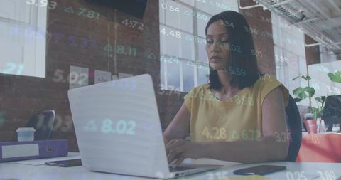 Businesswoman Analyzing Stock Market on Laptop in Modern Office
