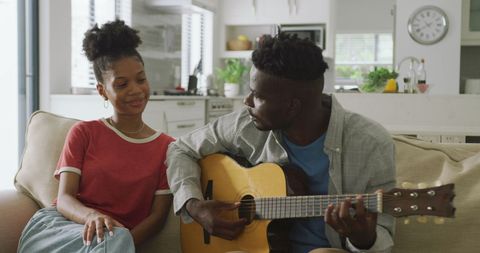 Happy Couple Enjoying Music Together on Sofa