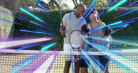 Smiling family playing tennis on backyard court with vibrant motion light rays