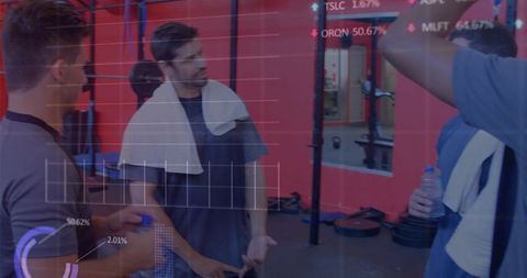 Group of men chatting by squat rack with towels and water bottles, fitness data overlay