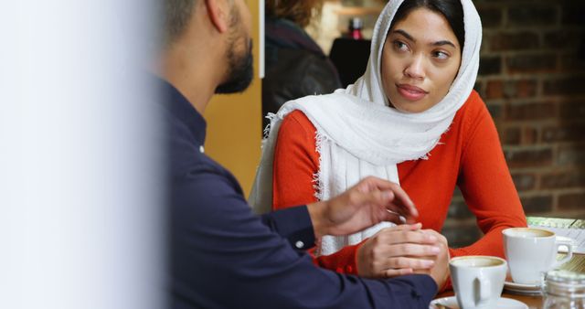 Muslim Woman in Hijab Conversing with Man at Coffee Shop - Download Free Stock Images Pikwizard.com