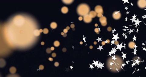 Golden bokeh orbs with white star confetti drifting on dark background